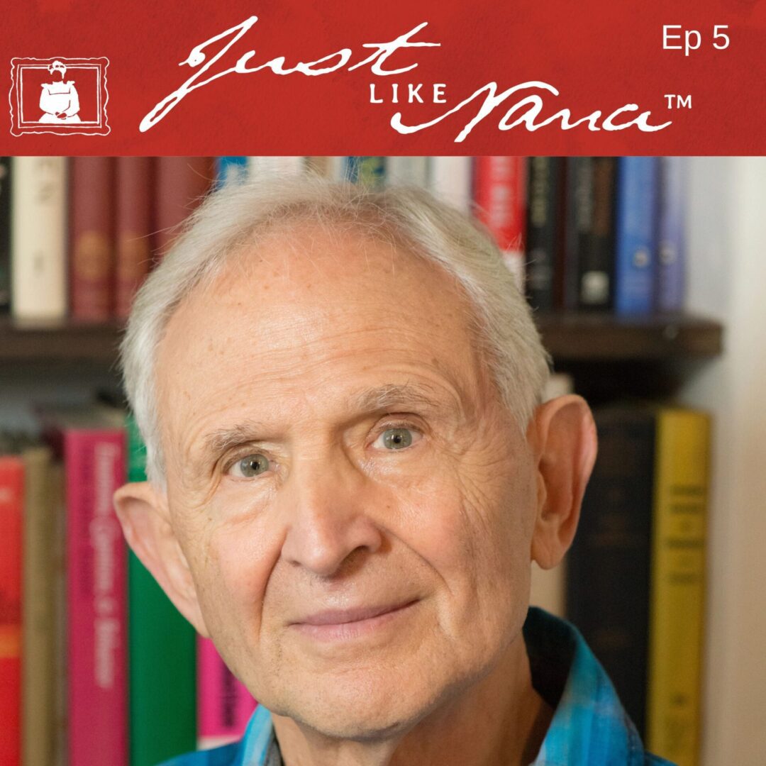 Elderly man smiling in front of bookshelf